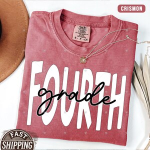 Op de afbeelding: Een rood T-shirt met de woorden "FOURTH grade" in witte letters. Het shirt heeft een verweerde look en is gemaakt van een zachte, comfortabele stof.