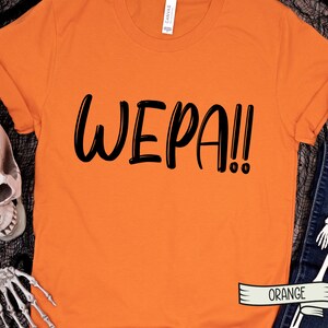 May include: Orange t-shirt with the text "WEPA!!" in black lettering.