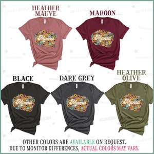 Puede incluir: Cinco camisetas de diferentes colores con la palabra "Mama" en una fuente retro rodeada de flores. Los colores son malva jaspeado, granate, negro, gris oscuro y oliva jaspeado.