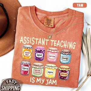 Puede incluir: Una camiseta de color melocot&oacute;n con el texto "Assistant Teaching is my jam" y una fila de nueve tarros de dibujos animados con diferentes etiquetas, que incluyen "Lesson Prep", "Support", "Monitoring", "Encourage", "Organizing", "Behavioral Strategies", "Inspire" y "Supervising".