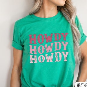 May include: A green t-shirt with the text "Howdy Howdy Howdy" in pink and red lettering.