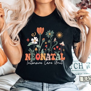 May include: Black t-shirt with a floral design and the text "Neonatal Intensive Care Unit" in colorful letters.