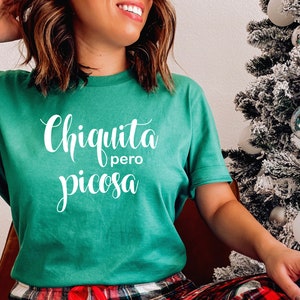 May include: A green t-shirt with the text "Chiquita pero picosa" in white lettering.