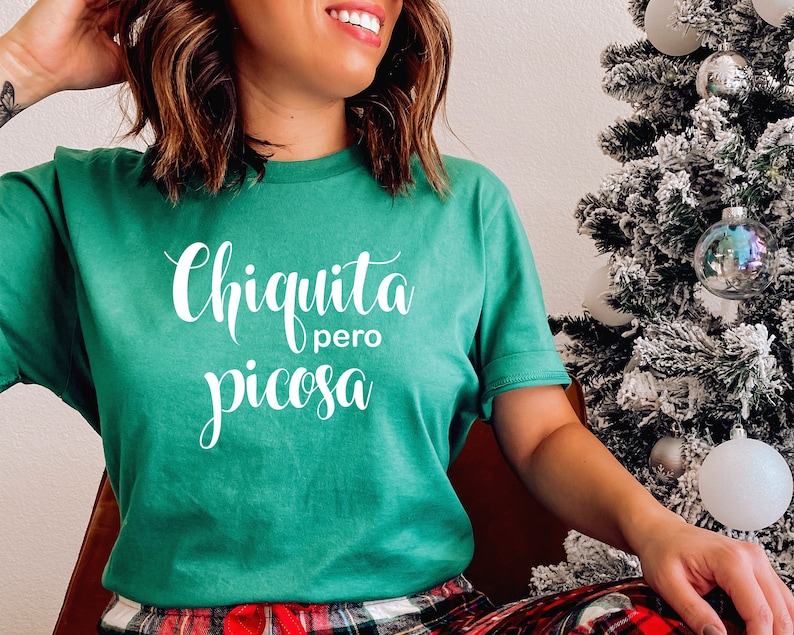 May include: A green t-shirt with the text "Chiquita pero picosa" in white lettering.