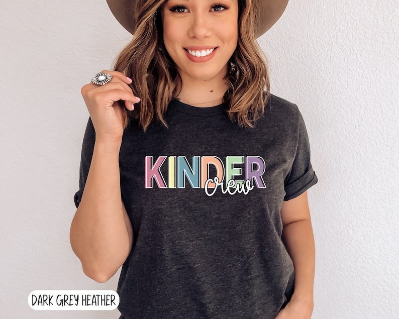 May include: Dark grey heather t-shirt with the text "Kinder Crew" in rainbow colors.