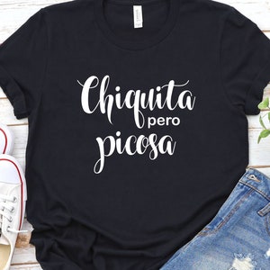 May include: Black t-shirt with white text that reads "Chiquita pero picosa".