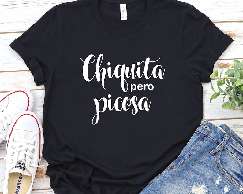 May include: Black t-shirt with white text that reads "Chiquita pero picosa".