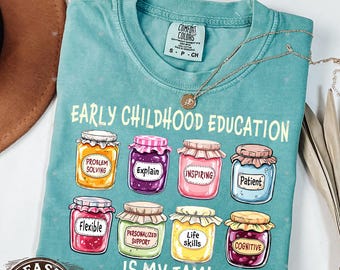 May include: A teal blue t-shirt with the text "Early Childhood Education is my jam!" and a graphic of eight jars of jam with different labels: "Problem Solving", "Explain", "Inspiring", "Patient", "Flexible", "Personalized Support", "Life Skills", and "Cognitive".