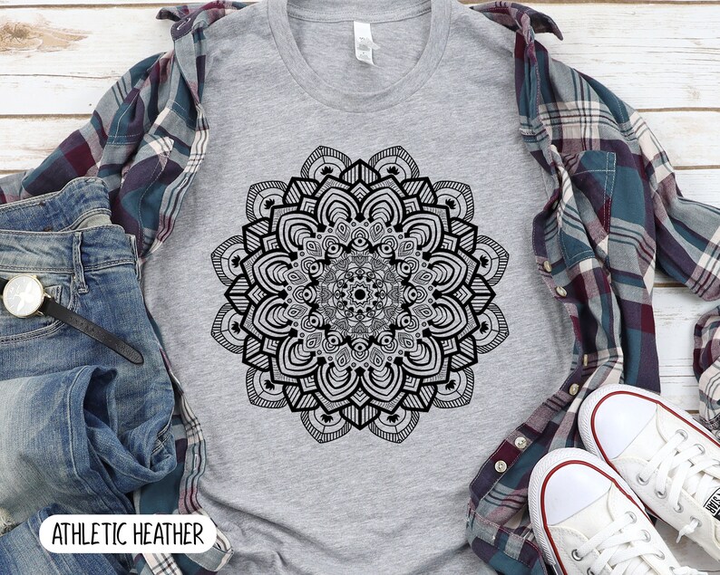 May include: A heather grey t-shirt with a black and white mandala design. The text "ATHLETIC HEATHER" is printed on the bottom of the shirt.