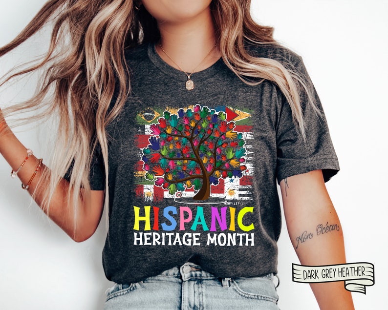 May include: A dark grey heather t-shirt with a colorful handprint tree design and the text "HISPANIC HERITAGE MONTH".