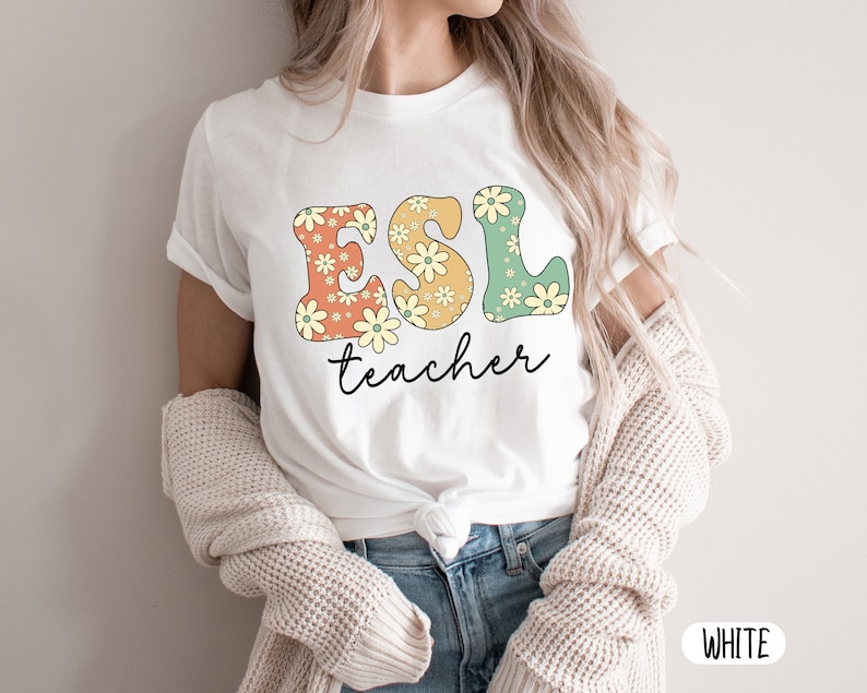 May include: White t-shirt with a floral design that spells out "ESL teacher".