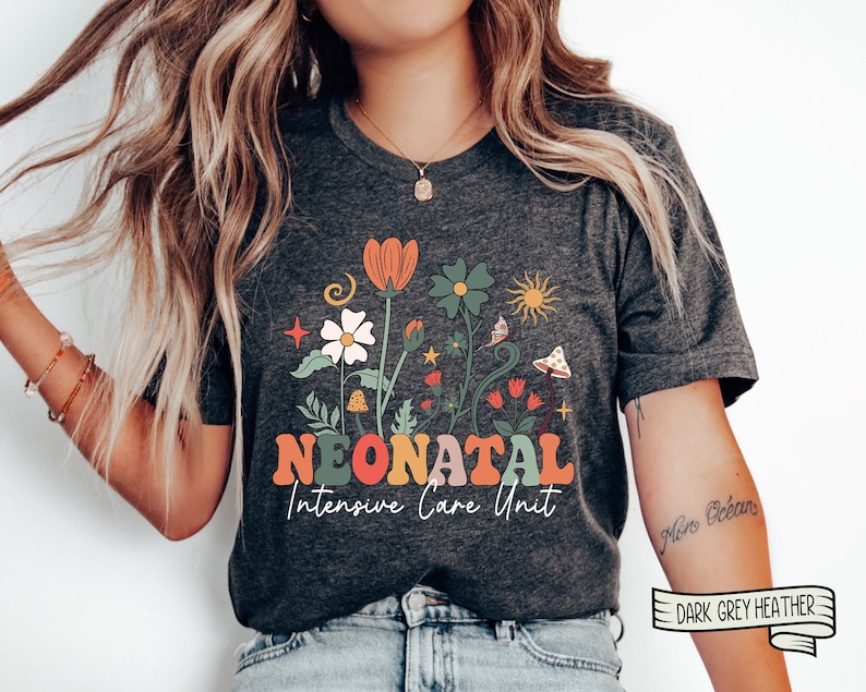 May include: A dark grey heather t-shirt with a floral design and the text "Neonatal Intensive Care Unit".