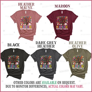 May include: Five t-shirts in different colors with a colorful tree graphic and the text "Hispanic Heritage Month". The colors are heather mauve, maroon, black, dark grey heather, and heather olive.