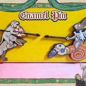 May include: Enamel pin featuring two medieval-style illustrations of animals in combat. One shows a dog and rabbit, the other a rabbit riding a snail. The text "Enamel Pin" is at the top.