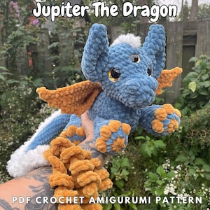 May include: Crochet amigurumi pattern for Jupiter the Dragon, a blue and orange crocheted dragon with three eyes. PDF crochet amigurumi pattern.