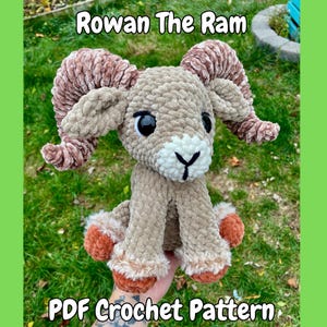 May include: A handmade crochet ram plushie with the text "Rowan The Ram" and "PDF Crochet Pattern". The ram has brown and tan fur, large brown horns, and black eyes. The plushie is a soft, cuddly toy.