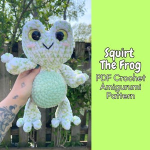 Könnte beinhalten: Ein gehäkeltes Frosch-Amigurumi in Grün- und Weißtönen, mit großen, ausdrucksstarken Augen und einem hellgrünen Bauch. Der Text "Squirt The Frog PDF Crochet Amigurumi Pattern" ist auf grünem Hintergrund zu sehen.