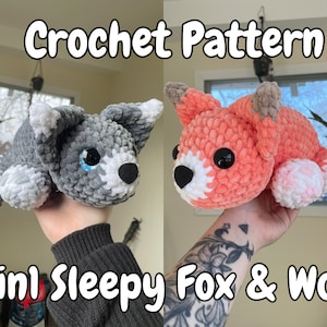 Puede incluir: Patrón de crochet para un zorro y un lobo dormidos. El zorro es naranja con patas blancas y el lobo es gris con patas blancas. Ambos animales tienen la nariz negra y los ojos azules.