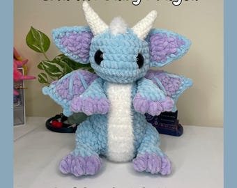 May include: A crochet pattern for Isla the Baby Dragon, a light blue and purple crocheted plush toy. The pattern is available as a PDF download.