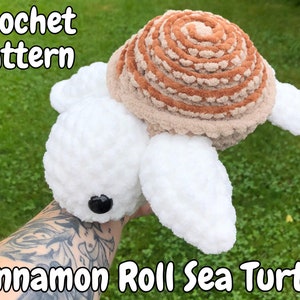 Puede incluir: Patrón de crochet para una tortuga marina de rollo de canela. La tortuga es blanca con un caparazón marrón que parece un rollo de canela.