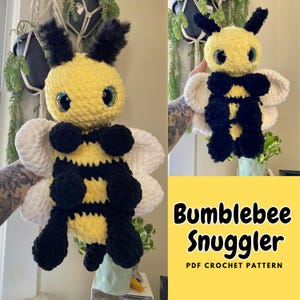 Peut inclure: Un jouet en peluche en forme de bourdon crocheté avec des rayures noires et jaunes, des ailes blanches et de grands yeux globuleux. Le jouet est tenu par une main. Le texte "Bumblebee Snuggler PDF CROCHET PATTERN" est affiché sous le jouet.
