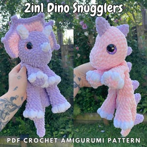 May include: Two crochet amigurumi dinosaur snuggle toys. One is purple and the other is pink. The pattern is available as a PDF download.