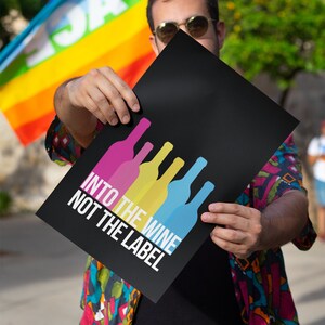 May include: A black poster with the text "Into the wine not the label" in white. The poster features a row of five colorful wine bottles in silhouette.