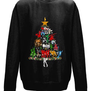 May include: Black sweatshirt with a Christmas tree design featuring characters from popular musicals. The tree is decorated with ornaments and lights. The text "CONNOR" is at the bottom of the tree.
