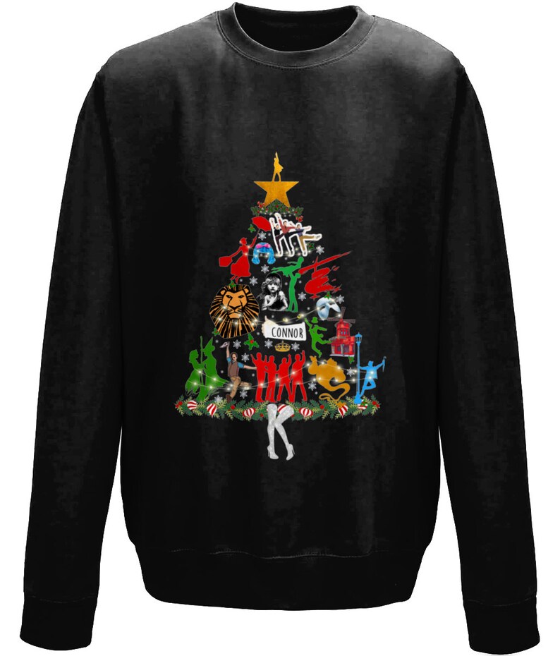May include: Black sweatshirt with a Christmas tree design featuring characters from popular musicals. The tree is decorated with ornaments and lights. The text "CONNOR" is at the bottom of the tree.