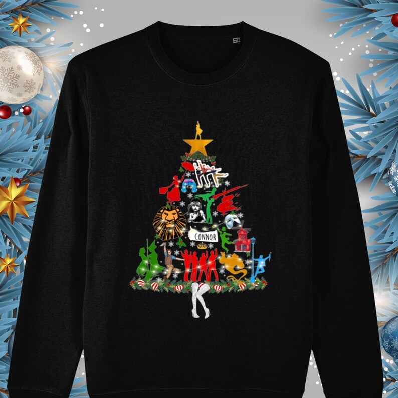 May include: Black long-sleeve sweatshirt with a Christmas tree design featuring various musical characters and the name "Connor" at the bottom.