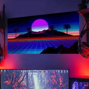 Puede incluir: Una impresión de arte digital de estilo retro con una puesta de sol sobre un paisaje cuadriculado. La impresión presenta un sol morado con rayas rosas y azules, palmeras y una cordillera. Los colores son vibrantes y la estética general recuerda a la década de 1980.