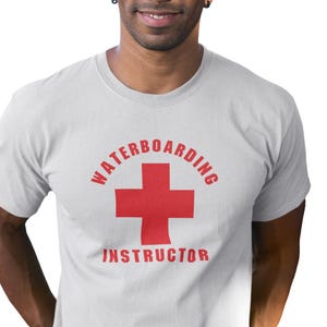 May include: A white t-shirt with the text "Waterboarding Instructor" in red letters, with a red cross symbol in the center.