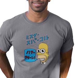 Op de afbeelding: Een grijs T-shirt met een cartoon afbeelding van een geel personage met blauwe ogen en een spraakballon die "WOO-HOO!" zegt in het Japans. De tekst boven het personage zegt "Mister Sparkle" in het Japans.