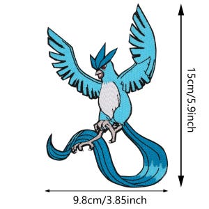 May include: Embroidered patch depicting a blue bird with raised wings and a long, flowing tail. The patch is 15 cm high and 9.8 cm wide. The bird has a white chest and red accents. A decorative item.