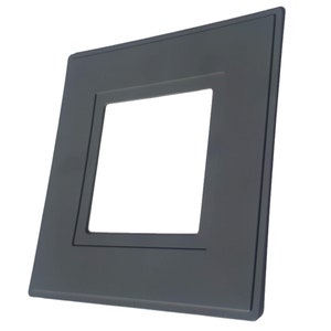 May include: A dark grey plastic wall plate with a square cutout in the centre. The plate is designed to be used for electrical outlets or switches.