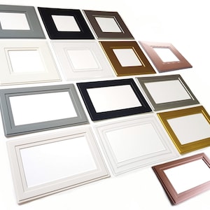 May include: A selection of picture frames in various colours and sizes. The frames are made from wood and have a simple, modern design.