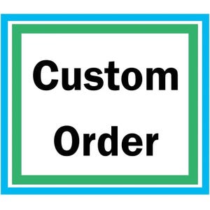 May include: A blue and green framed sign with the text "Custom Order" in black.