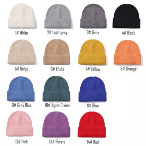 May include: A set of 14 knit beanies in various colors, including white, light grey, grey, black, beige, khaki, yellow, orange, grey blue, agate green, blue, pink, purple, and red. Each beanie has a ribbed texture.