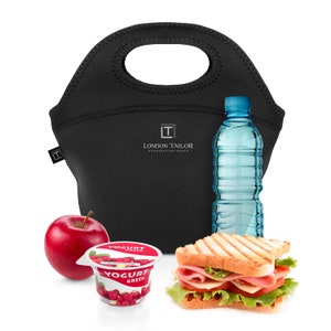 Puede incluir: Bolsa de almuerzo aislada negra con asa, una botella de agua, un s&aacute;ndwich, un recipiente de yogur y una manzana roja. La bolsa de almuerzo tiene el texto "London Tailor Handcrafted Goods" impreso.