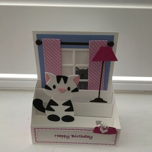 Scheda pop-up scena gatto alla finestra di casa