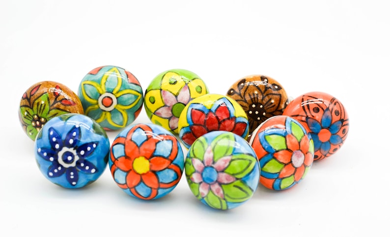 以下が含まれることがあります： 花柄のデザインが施されたカラフルなセラミック製のノブが10個セットになっています。ノブは丸型で光沢のある仕上げになっています。どんな部屋にも遊び心を取り入れるのに最適です。