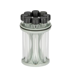 May include: A clear, cylindrical container with eight small, black-capped vials arranged in a circle. The container has a light gray base and top, and the vials are visible through the clear sides. The design is modern and functional.