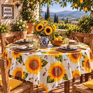 Peut inclure: Une nappe ronde ornée d'un motif de tournesols éclatants sur fond blanc, recouvrant une table dressée avec des assiettes, des serviettes, des verres verts, un pichet en céramique rempli de tournesols et un bol de citrons.