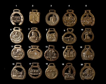 Puede incluir: Veinte  brass de caballo de latón, cada uno con un diseño diferente de un castillo o edificio. Los brass están numerados del 1 al 20.