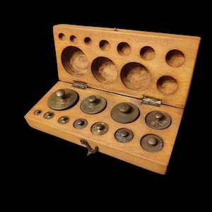 Vintage set of bronze weights for scales in a wooden box
