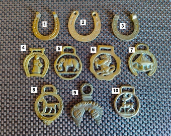Puede incluir: Diez  bronce de caballo de latón con diferentes diseños, incluyendo una herradura, un elefante, un león, una iglesia, un caballo, un ciervo y un caballero. Los bronces están numerados del 1 al 10.