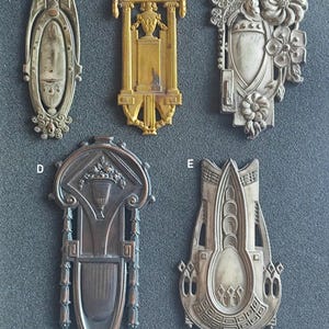 Könnte beinhalten: Fünf antike dekorative Metallstücke in verschiedenen Stilen. Die Stücke sind in Silber-, Gold- und Bronzetönen gehalten. Jedes Stück weist komplizierte Designs und Details auf.