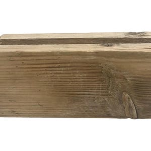 Könnte beinhalten: Eine rustikale Holzkiste mit natürlicher Holzoptik. Die Kiste besteht aus zwei zusammengefügten Holzstücken. Das Holz hat eine natürliche Maserung und ist leicht verwittert.