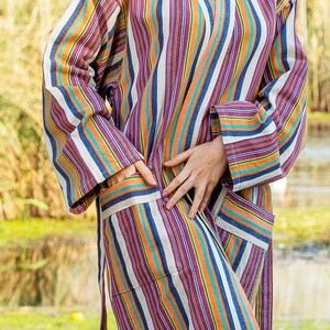 May include: A striped robe with a long sleeve and a sash tie. The robe is made of a soft, comfortable fabric and features a variety of colors, including orange, blue, purple, and white.