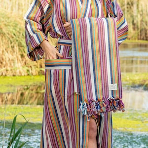 May include: A striped robe with a matching striped towel. The robe has a sash and pockets. The towel has fringe on the bottom.